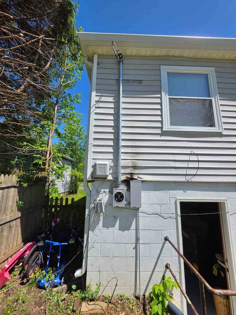 Meter socket and service mast on the side of a house, newly replaced